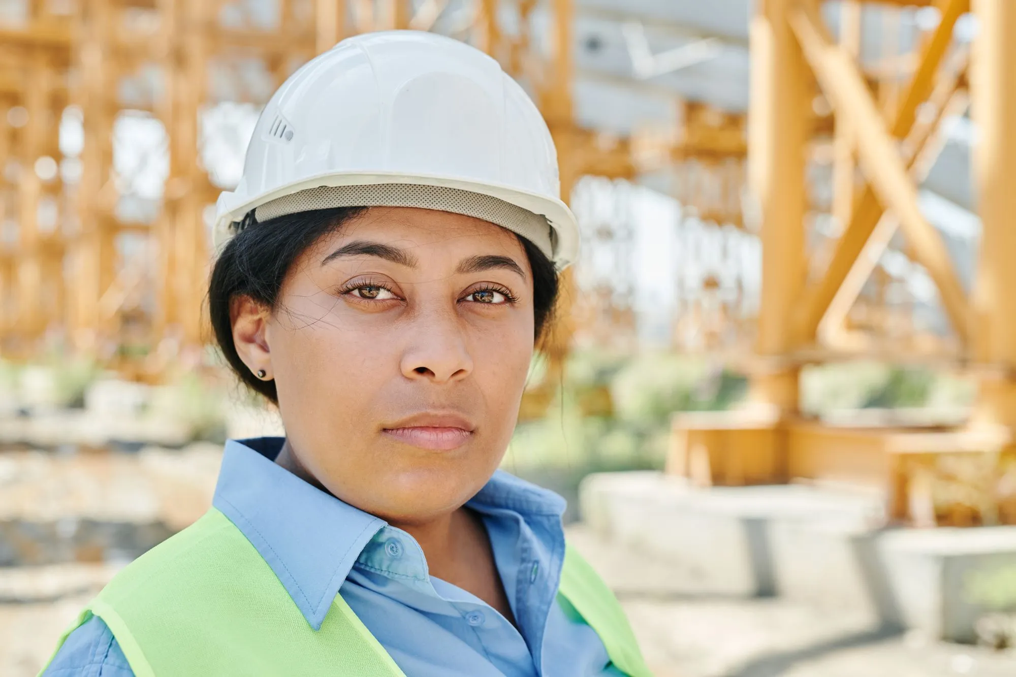 Profesional colombiana con casco de seguridad, confiada y lista para trabajar